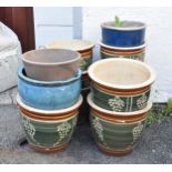 A collection of eight garden pots, having green/blue glaze with incised grape decoration, the