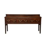 A George III oak dresser base, the short, moulded upstand over a plain moulded top with three