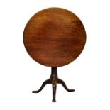 A George III mahogany tilt-top tripod supper table, the circular top on a turned gun barrel column