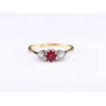 An 18ct gold, ruby and diamond trilogy ring, the round cut ruby of pinkish red colouring, in an 8