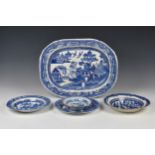 A 19th century blue and white pearlware platter, decorated with the willow pattern, 17¾in. (45cm.)