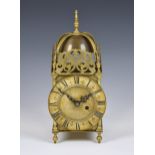 An early 20th century lantern clock, with brass 16cm. Roman dial, the case with foliate pierced