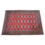 A Bokhara rug, the three rows of nine Guls on a red field, with a geometric main border flanked by