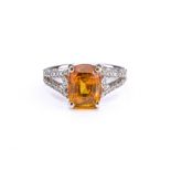 An 18ct white gold, yellow sapphire and diamond ring, set with a cushion-cut yellow sapphire,