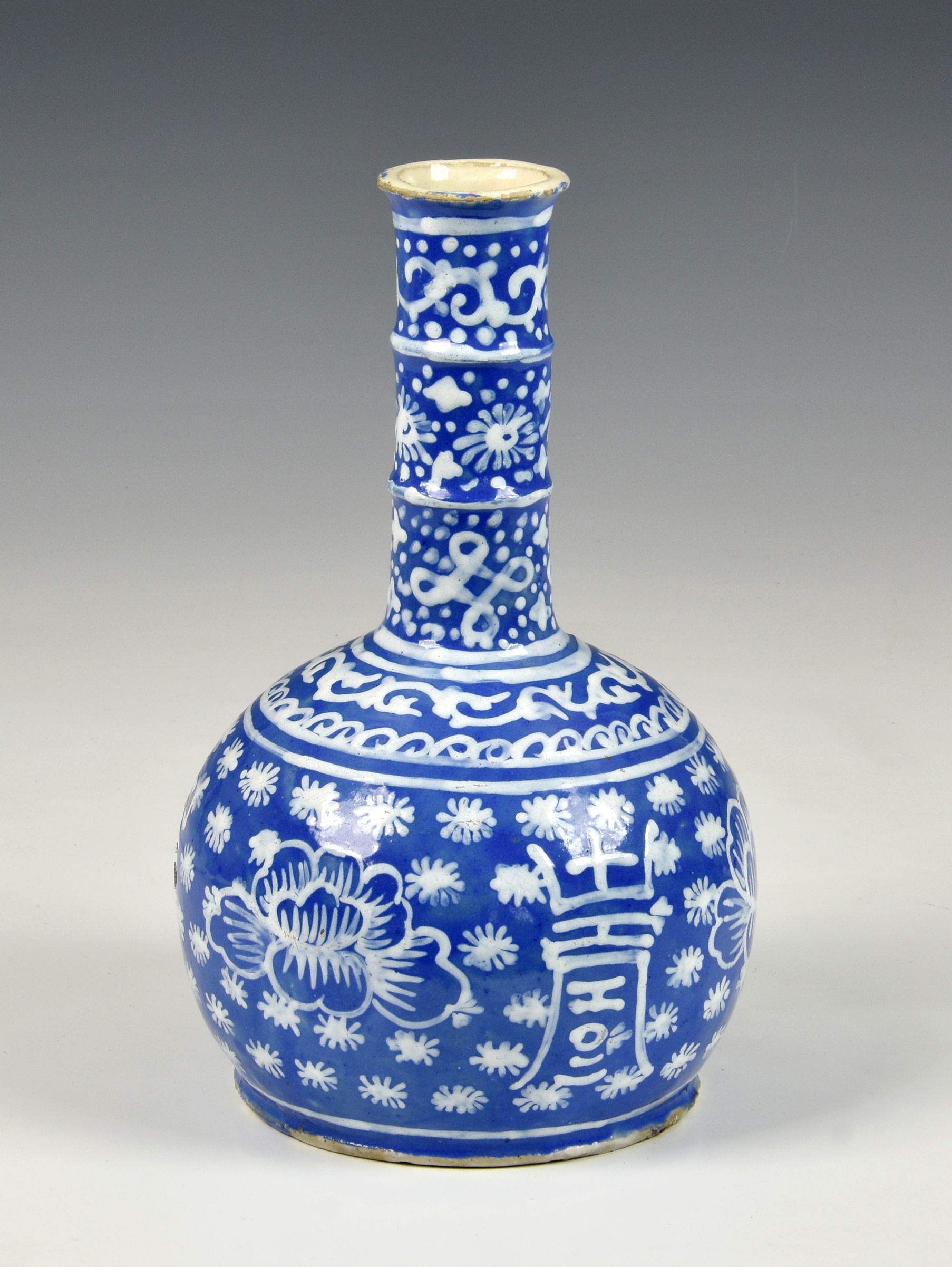 A Chinese slip decorated blue glazed stoneware bottle vase, probably 19th century, the cylindrical