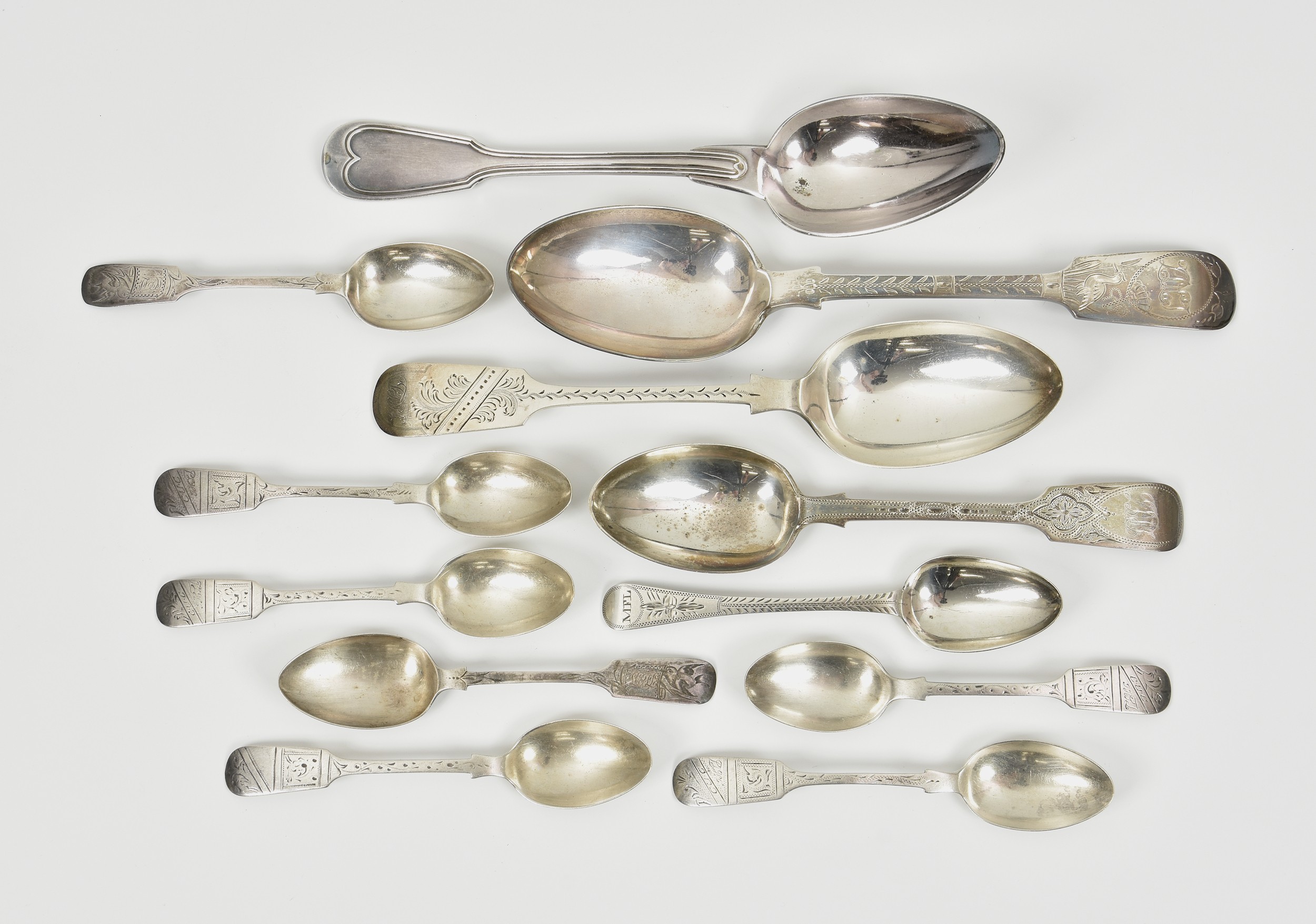 A collection of bright cut fiddle pattern silver spoons, to include a table spoon by Josiah Williams