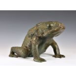 A large cast bronze toad, with warty skin and realistic features, 17 ¾in. (45cm.) long, 12in. (30.