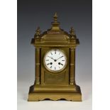 A French brass architectural mantel clock, 19th century, the white Roman enamel dial fronting a