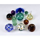 A collection of 20th century glass paperweights, comprising a clear glass weight with arum lily