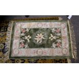 A small Chinese silk rug, late 20th century, the central sage green field with floral decoration,