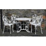 A cast metal Guernsey Lily garden table and four chairs, the table 35in. (88.9cm.) diameter, 27 ¼in.