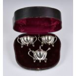 A cased set of Arts & Crafts silver condiments, Walker & Hall, Sheffield, 1906 & 1909, of organic