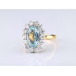 An 18ct gold, aquamarine and diamond cluster ring, the central, approx. 2.43ct oval cut aquamarine