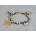 A 9ct rose gold charm bracelet, hallmarked London 1927, the curb link bracelet with two 9ct gold