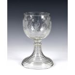 A Victorian oversized glass goblet, having etched decoration of Bacchus amidst grape vine, raised on