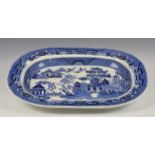 A large blue and white Willow pattern meat platter, of typical oval form with deep dish,