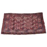 An antique Bokhara rug, with three rows of four gols on a madder field, within a border of cross and