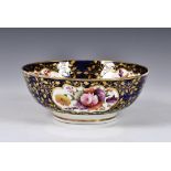 A 19th century English porcelain bowl, probably Spode, having all over floral decoration on a blue &