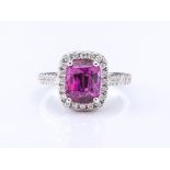 An 18ct white gold, pink sapphire and diamond ring, set centrally with an approx. 3.10ct cushion-cut