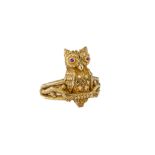 An 18ct yellow gold owl ring, unmarked, tests as 18ct gold, the owl with inset pink stone eyes, on