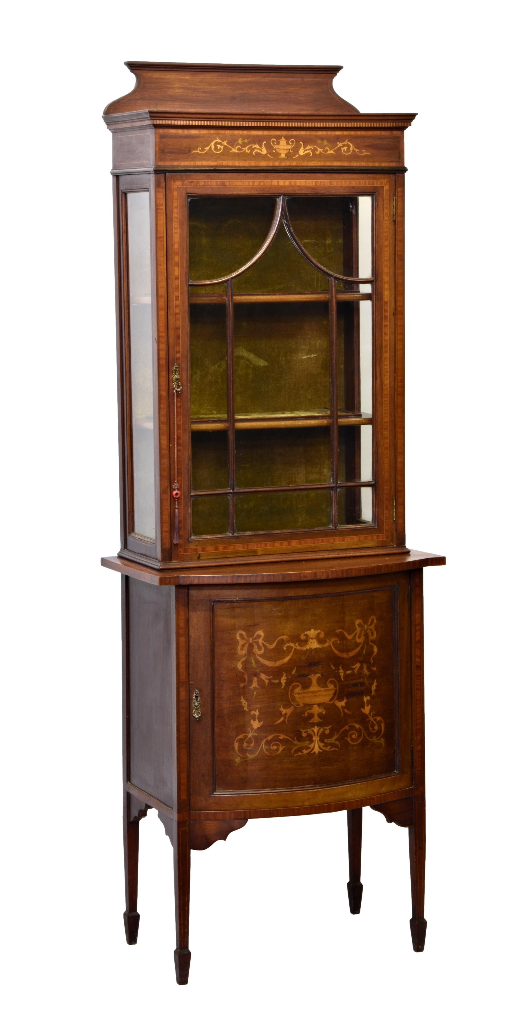 An Edwardian mahogany, satinwood cross banded and marquetry part-glazed cabinet, the short, shaped