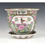 A Chinese famille rose jardiniere and saucer, 20th century, painted with two reserves with