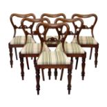 A set of six Victorian walnut balloon back dining chairs, with pierced scroll backs and drop-in