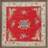 A Chinese embroidered silk panel, probably early 20th century, the red floral damask ground