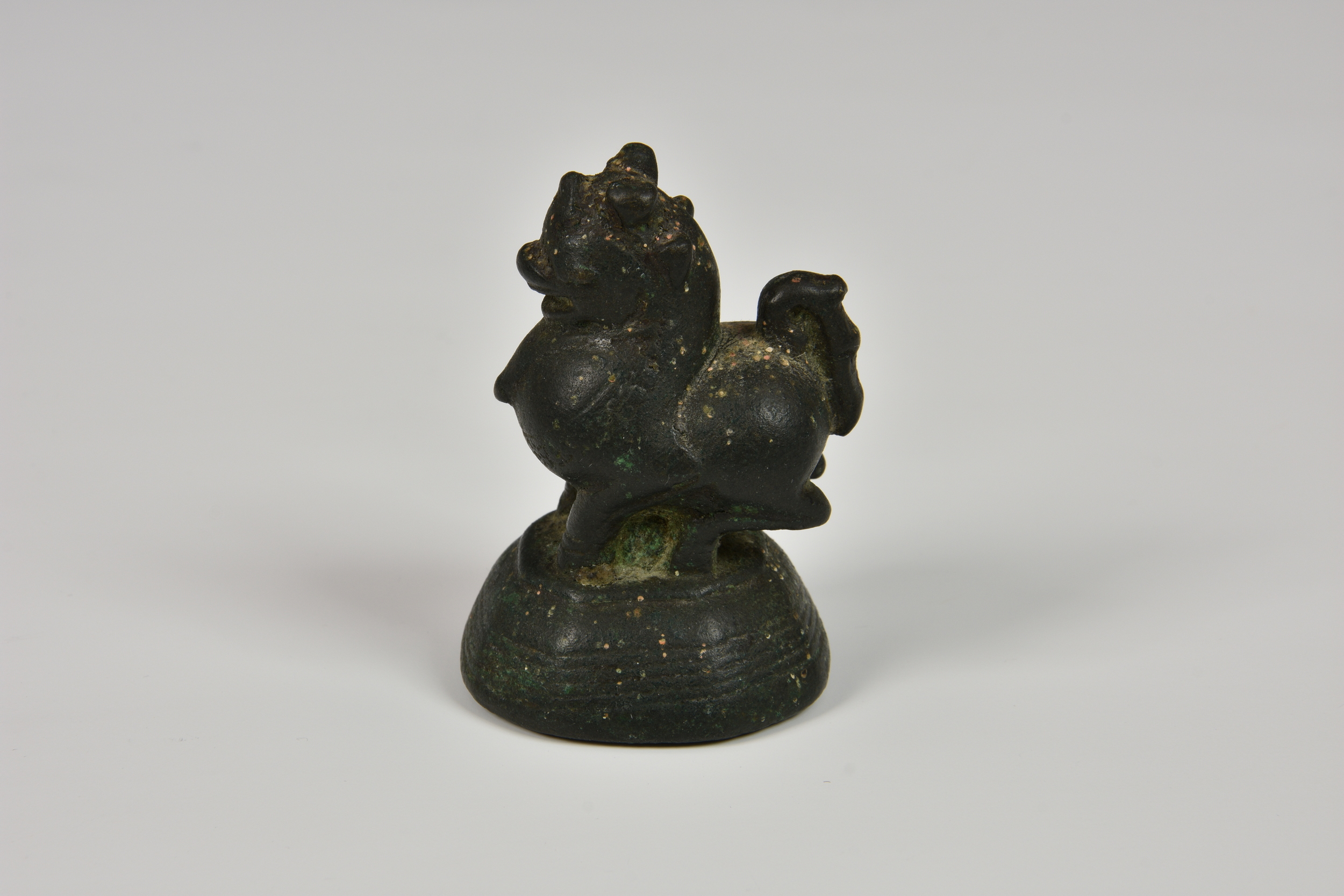 An 18th / 19th century Burmese cast bronze opium weight, in the form of Chinthe, raised on a - Image 2 of 5