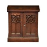 A Victorian Gothic Revival oak table cabinet, the Gothic window panelled doors enclosing a fitted