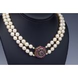 A two row pearl necklace with 9ct gold gem set clasp, the evenly sized, 8mm. pearls with a target