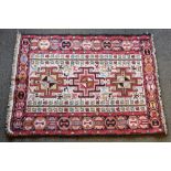 A small Turkoman rug, the field with three hooked medallions, stylised animals, insects and trees,