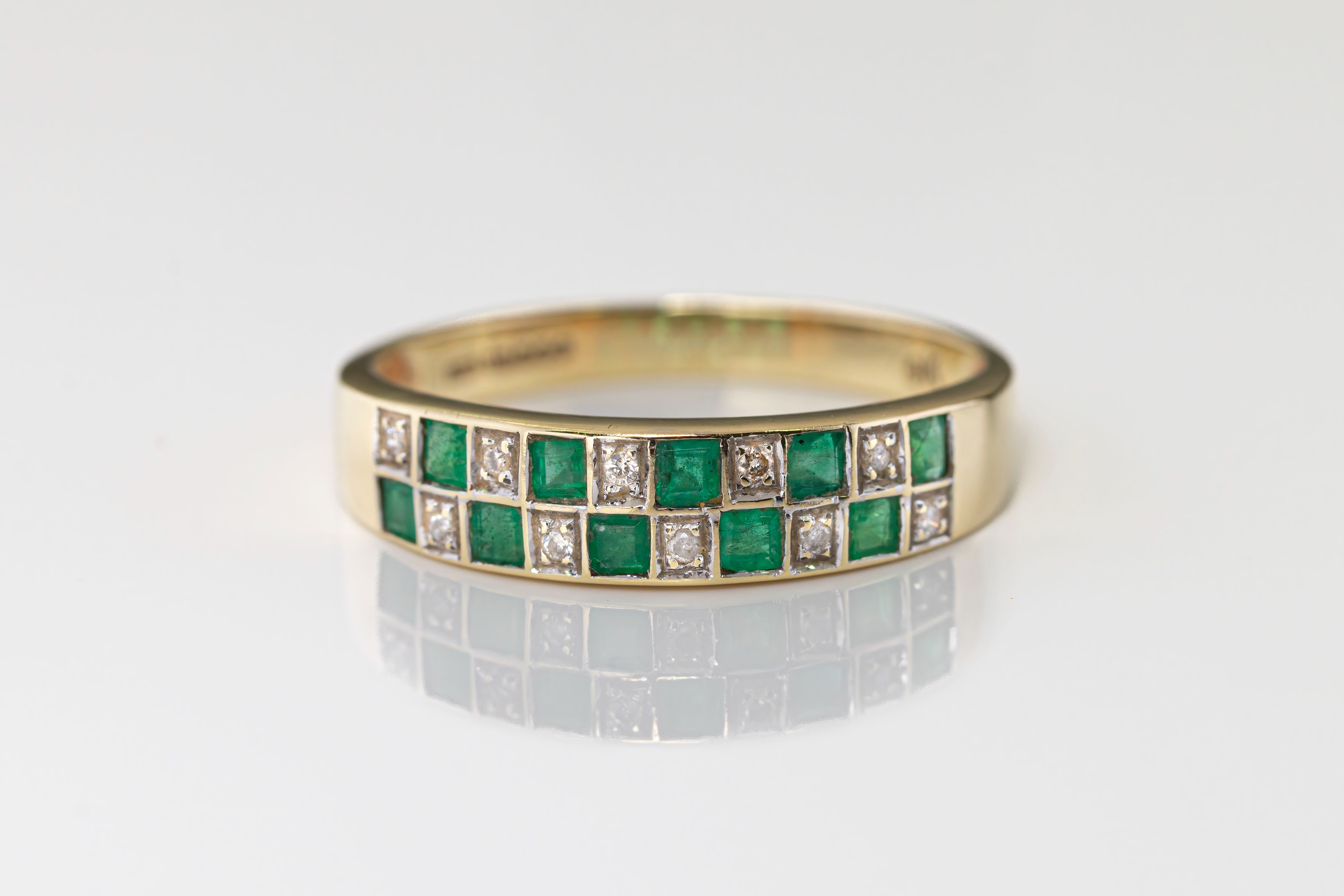 A 9ct gold, diamond and emerald half-eternity ring, of checkerboard design, with an alternating
