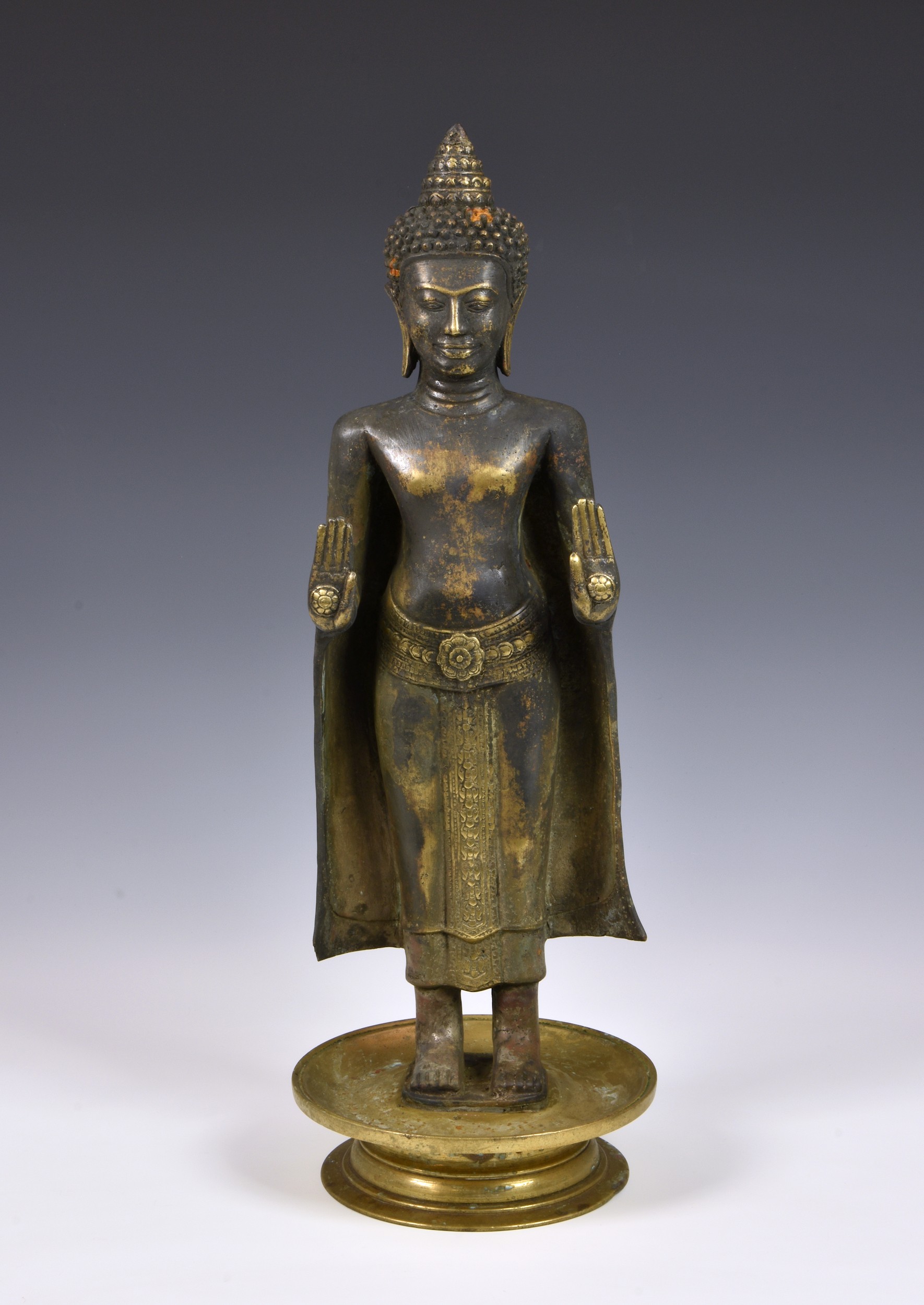 A gilt and black-lacquered figure of Buddha Shakyamuni, Thailand, cast metal Buddha, standing in