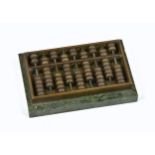 A vintage miniature abacus paperweight, of rectangular form with brass counters, raised on green