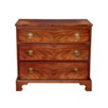 An early 19th century three drawer mahogany chest, the boxwood and ebony strung top over three