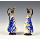 A pair of Royal Doulton Burslem ewer vases, decorated with blue reeds on white ground with gold