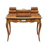 An English burr walnut, kingwood, gilt brass and porcelain mounted serpentine writing table