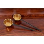 A pair of brass and wrought iron warming pans with monkey tail terminals