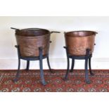 Two antique copper cauldrons on wrought iron stands, 19th / early 20th century