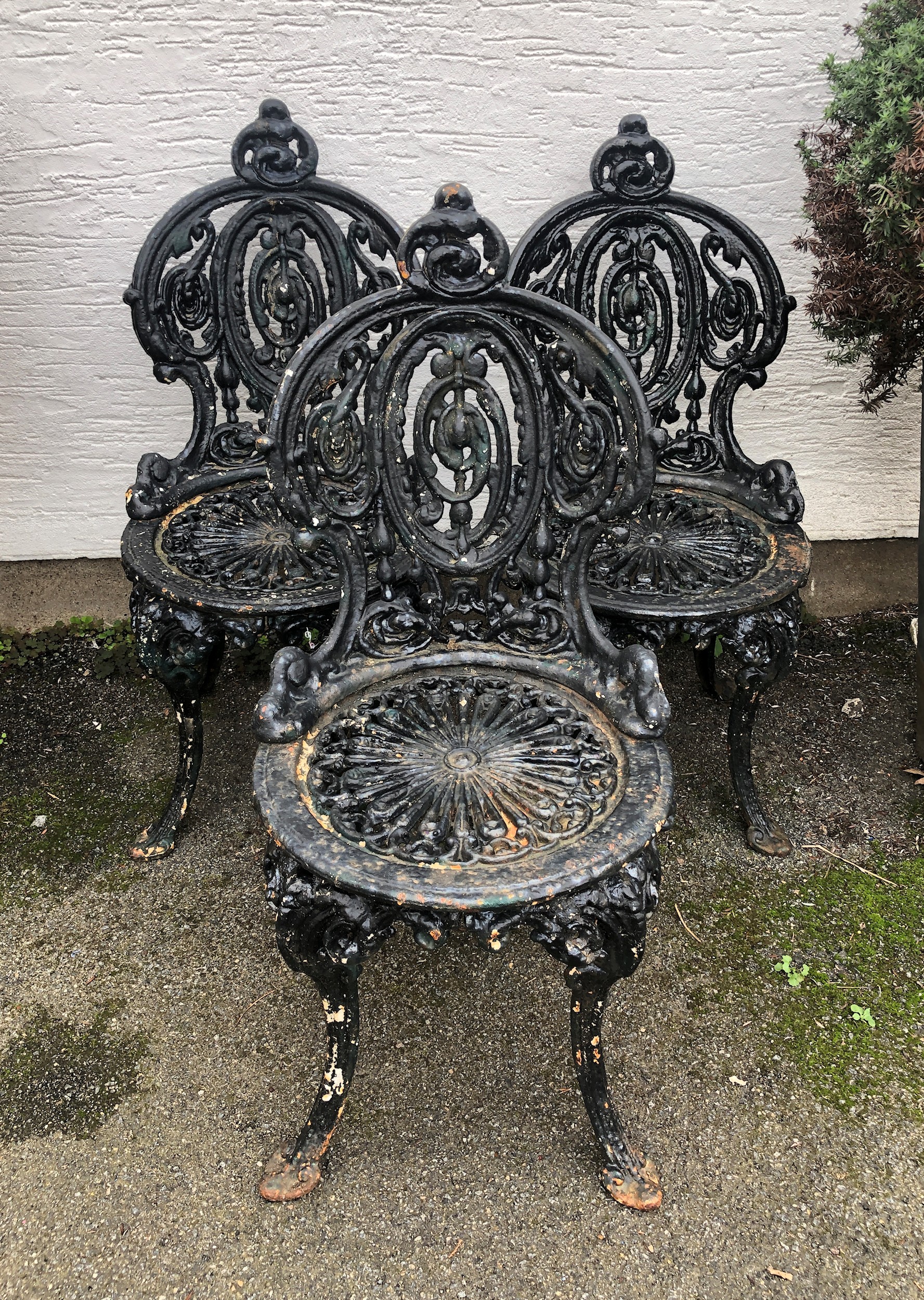 A set of three Victorian cast iron garden chairs in the style of Coalbrookdale