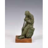 A bronze painted resin sculpture of a fisherman mending his nets