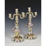 A pair of Continental figural porcelain three branch candelabra, probably early 20th century,