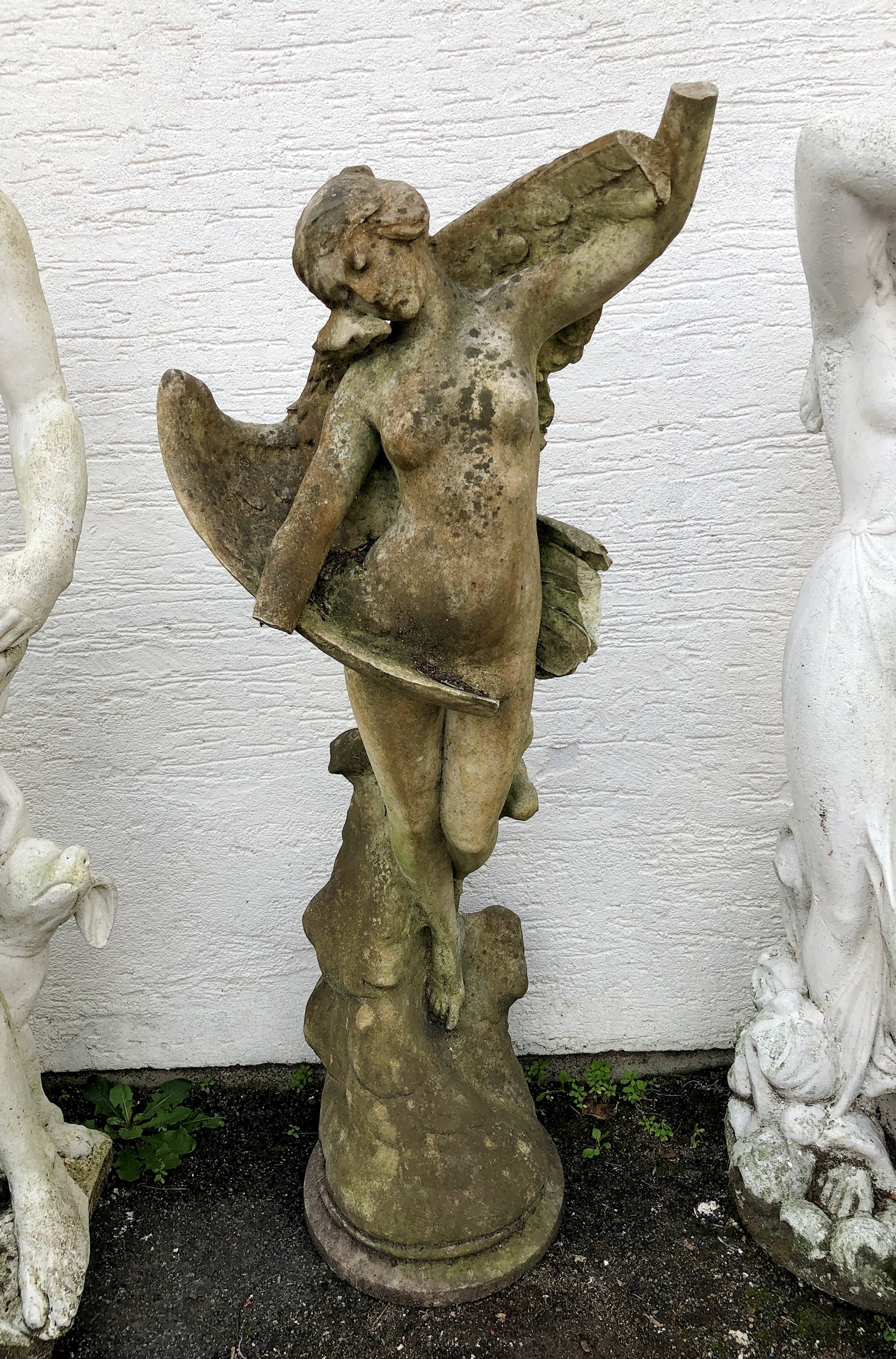 A well weathered marble garden statue of a maiden and eagle