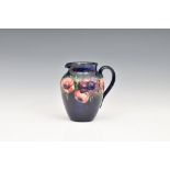 A Moorcroft Pottery jug, 'anemone' pattern, dark blue ground, , blue signature marks 'Potter to