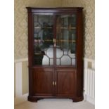 A large George III part-glazed mahogany floorstanding corner cupboard, of imposing proportions,