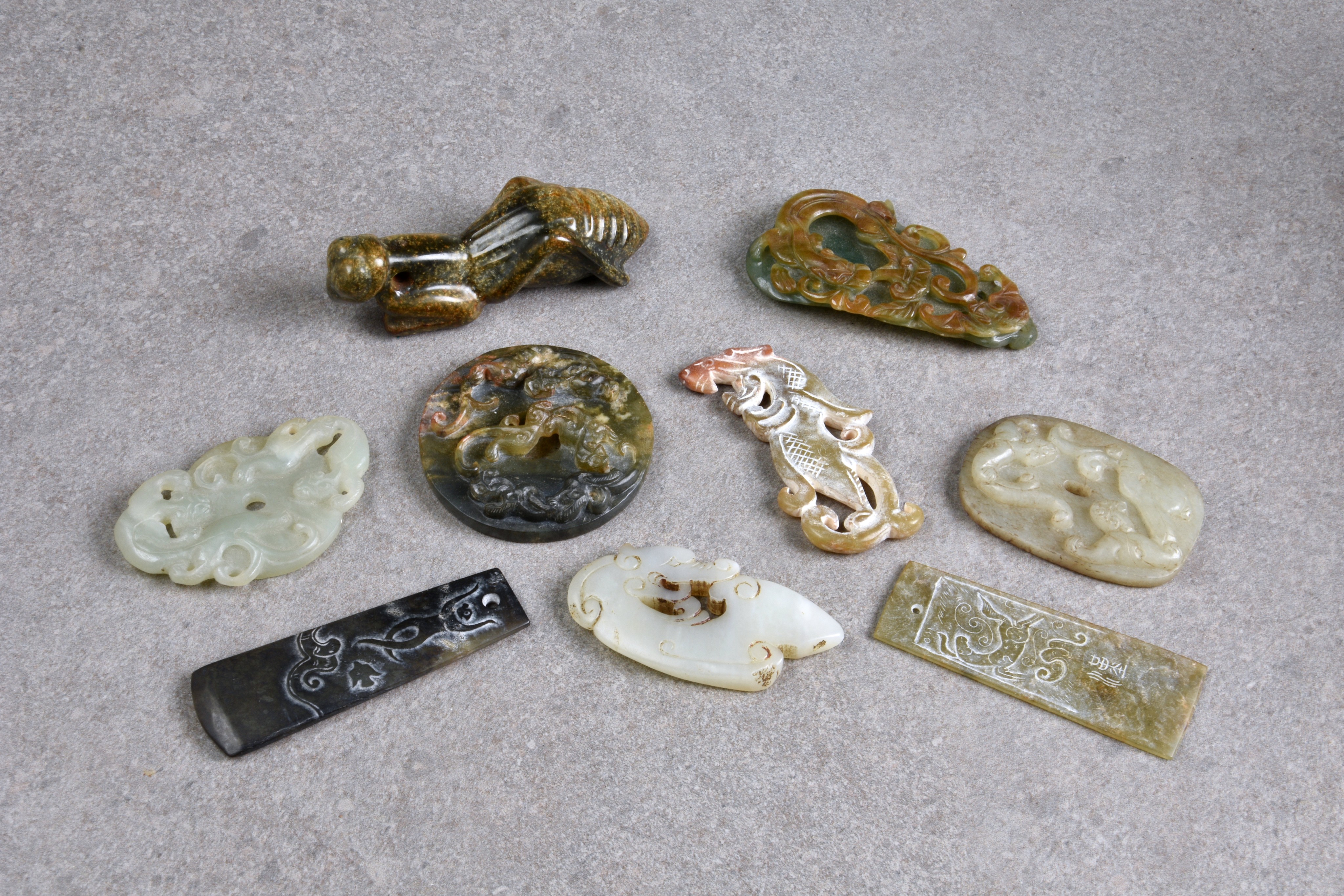 Nine Chinese jade carvings, all probably 20th century, including a praying mantis, a disc carved