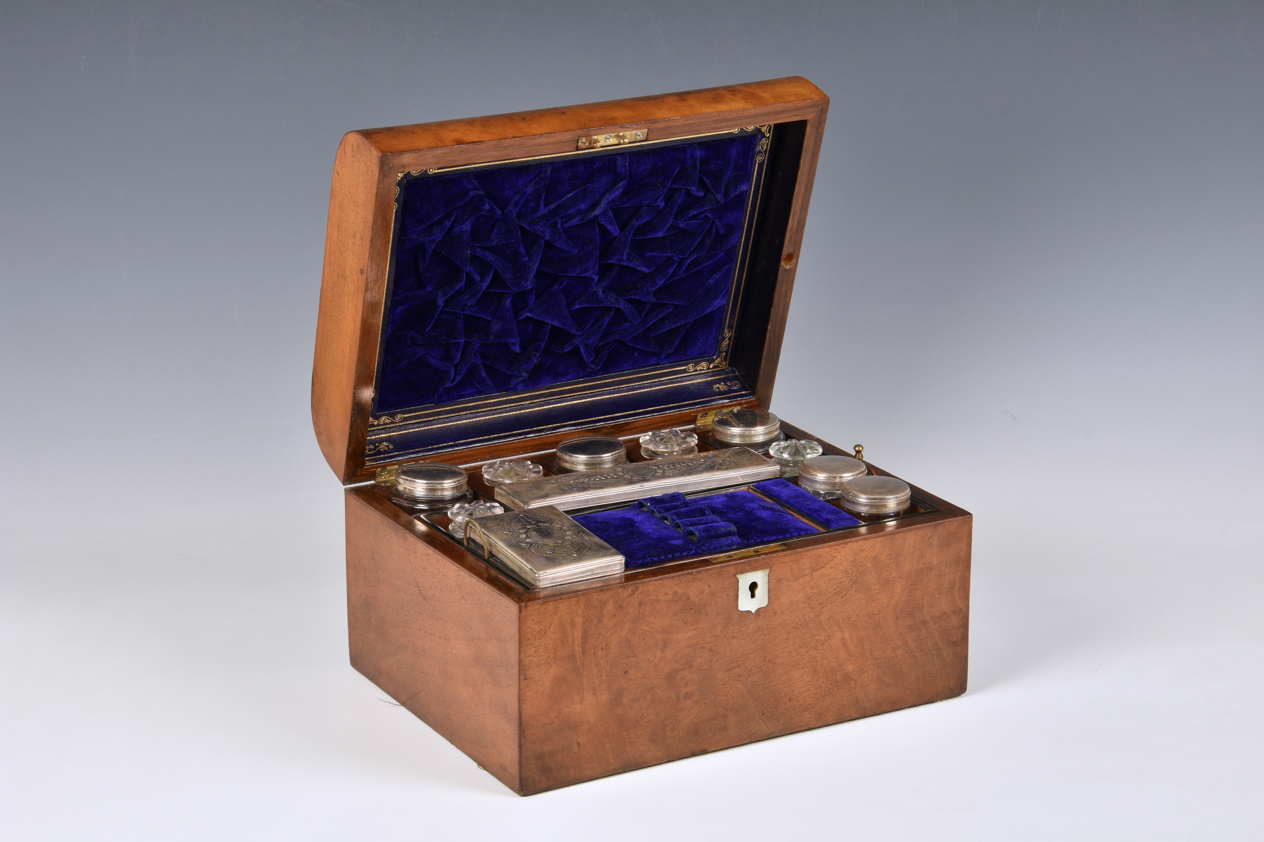 A Victorian walnut toilet box, of casket form with mother of pearl shield shaped escutcheons,