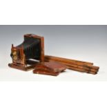 A Thornton Pickard mahogany cased field camera with tripod, brass fittings and lens, having