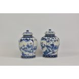 A pair of Chinese porcelain blue and white lidded baluster vases, decorated with panels of garden